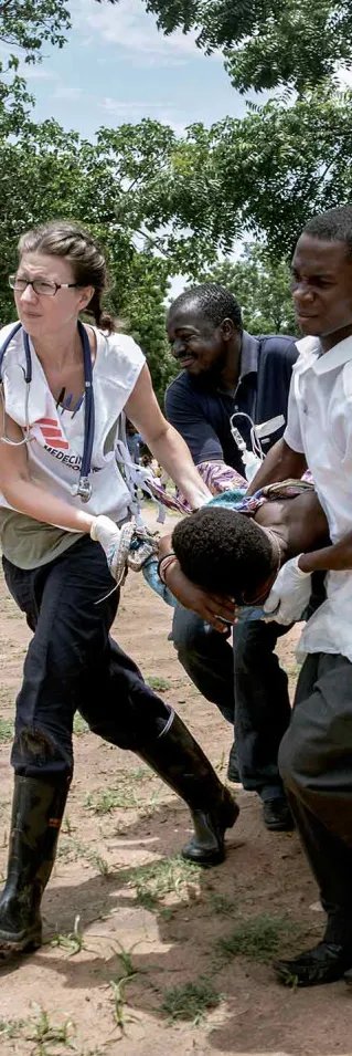 Four medical workers are carrying a patient.