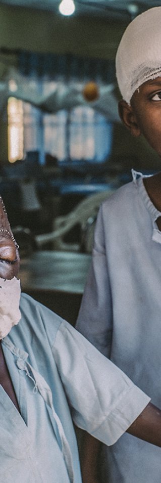 Åttaåriga Umar och femtonåriga Adamu står vid ingången till den postoperativa avdelningen på Sokoto sjukhus.