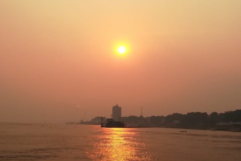 En sol ovanför vatten och land