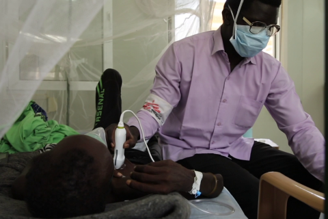 En man i munskydd behandlar en patient med tuberkulos