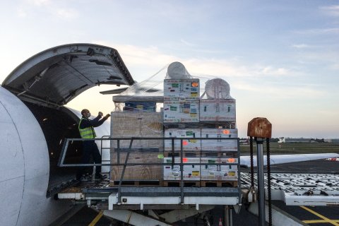 Pallar med medicinsk utrustning plockas in på ett plan