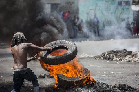 En demonstrant bränner däck i Port-au-Prince