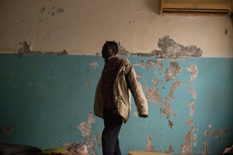 En man tar på sig en kavaj.