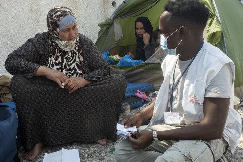 Läkare Utan Gränsers medarbetare pratar med 67-åriga Jayzah, efter branden i Morialägret på den grekiska ön Lesbos.