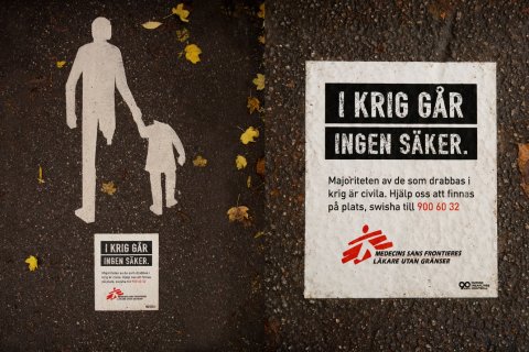 En bild på ett trasigt övergångställe med en skylt av Läkare Utan Gränser bredvid där det står "I krig går ingen säker"