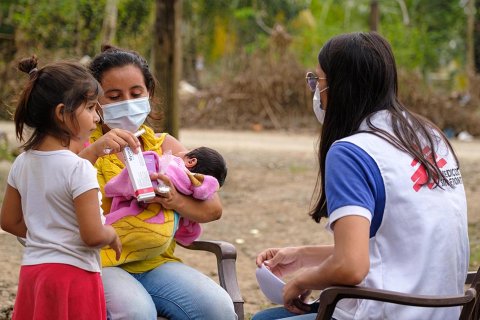 En anställd från Läkare Utan Gränser samtalar med en kvinna och hennes två barn i Choloma, Honduras.
