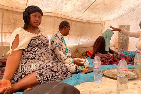 Safi Keita, som är gravid, sitter i ett tält tillsammans med andra kvinnor i Assamaka, Niger.