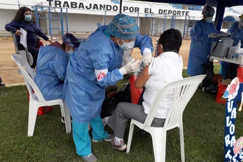 Personal från Läkare Utan Gränser vaccinerar en kvinna i Peru mot covid-19.