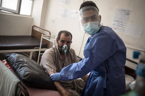 En sjukvårdsanställd tittar till en patient som får syrgas på sjukhuset i Raqqa i nordösta Syrien. 
