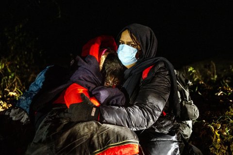 En mamma från Irak kramar sina döttrar, någonstans vid gränsen mellan Polen och Belarus