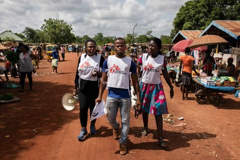 Tre hälsoinformatörer från Läkare Utan Gränser går på en gata i delstaten Ebonyi i sydöstra Nigeria.