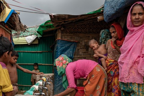 Kvinnor och barn står vid en vattenpost i lägret Jamtoli i Cox's Bazar i Bangladesh.