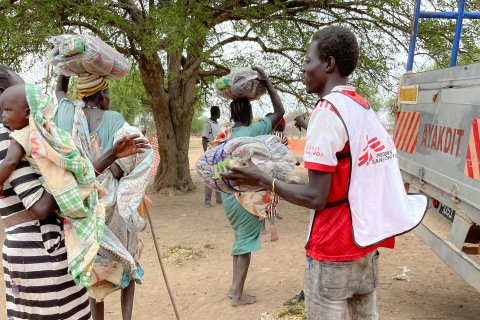 En medarbetare från Läkare Utan Gränser delar ut filtar i lägret Nyin Deng Ayuel, i Twic County, Sydsudan.