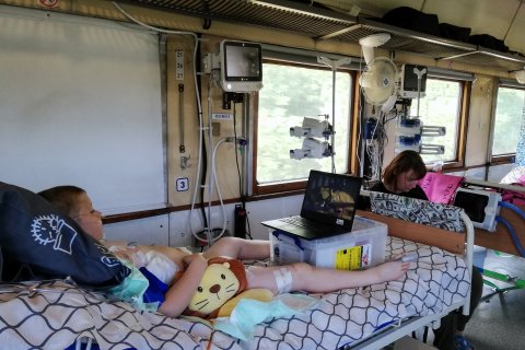 En pojke ligger i en sjukhussäng på Läkare Utan Gränsers evakueringståg i Ukraina