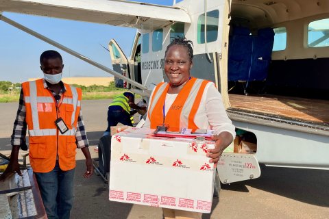 Stella utanför ett flygplan hållandes i ett paket