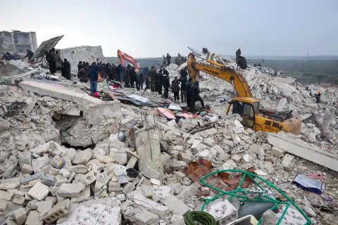 En grävskopa gräver i rasmossorna efter en stora jordbävning som drabbade Turkiet och Syrien.