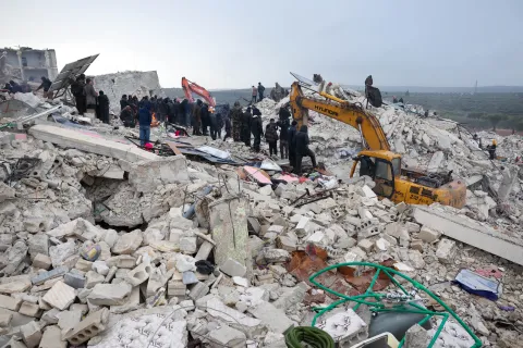 En grävskopa gräver i rasmossorna efter en stora jordbävning som drabbade Turkiet och Syrien.