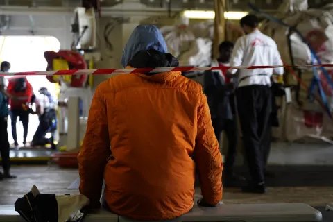 Ombord räddningsfartyget Geo Barents sitter en person med ryggen mot kameran