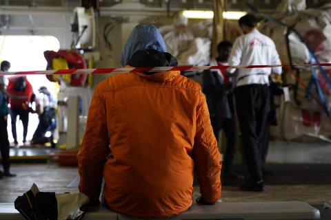 Ombord räddningsfartyget Geo Barents sitter en person med ryggen mot kameran