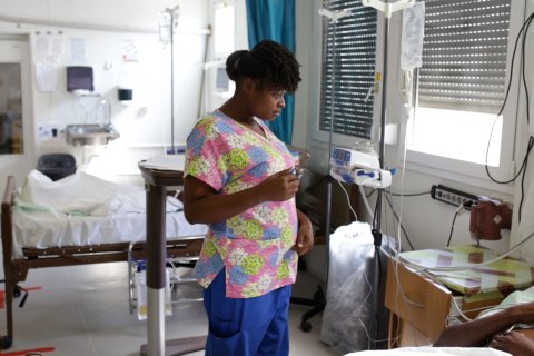 Sjuksköterskan Gessica i Haiti talar med en patient som ligger i en sjukhussäng