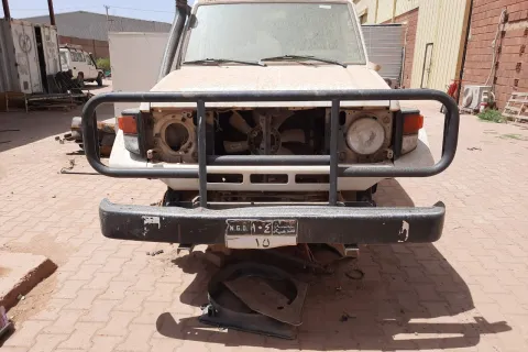 en bil utan däck och andra delar står vid ett av Läkare Utan Gränsers lager i Khartoum, Sudan