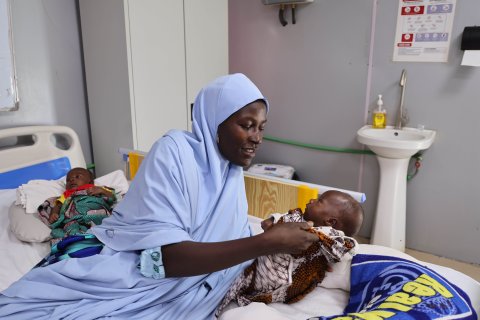 Kvinna med sina tvillingar som fått behandling för undernäring på sjukhuset.