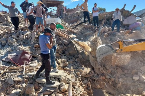 en grupp människor står i ett raserat hus