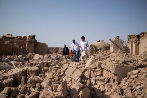 Tre medarbetare från Läkare Utan Gränser går över stora rasmassor efter jordbävningen i Afghanistan