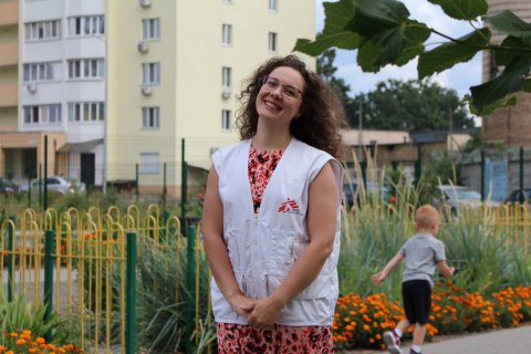 Kvinna ler mot kameran iklädd i MSF-väst.