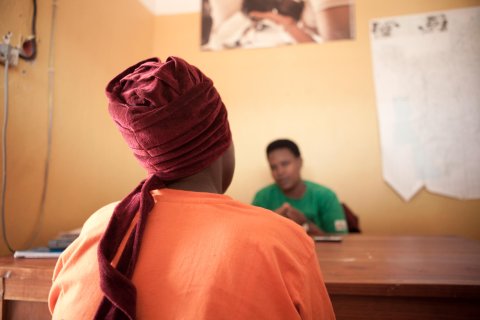 bild tagen bakifrån på en kvinna som sitter framför ett skrivbord