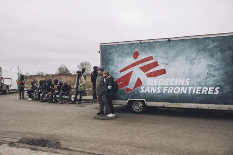 Människor väntar utanför Läkare Utan Gränsers mobila klinik i Calais.