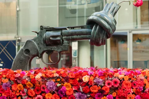 Staty an en pistol med knuten pipa, dekorerad med rosa rosor