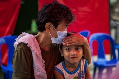 En äldre kvinna håller om ett yngre barn. 