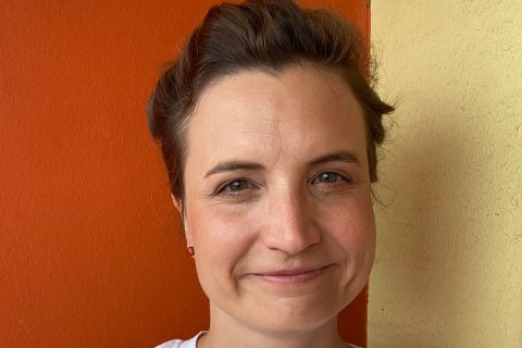 Kvinan ler och kollar mot kameran.