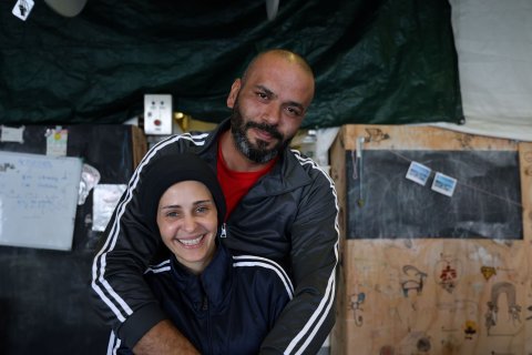 Två personer skrattar och kollar in i kameran.