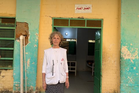 Kvinna står i Läkare Utan Gränsers väst framför sjukhuset.