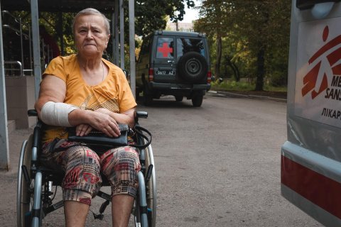 En kvinna i en rullstol utanför en ambulans