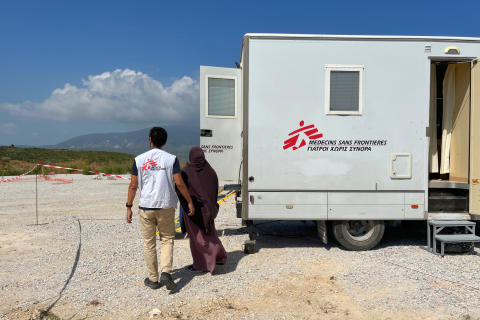 En anställd på Läkare Utan Gränser och en patient går mot mobil klinik