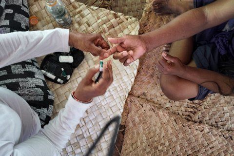 Närbild på två personers händer. Personen till vänster sticker personen till vänster i fingertoppen.