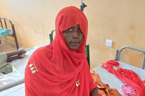 Kvinna sittandes på sjukhussäng