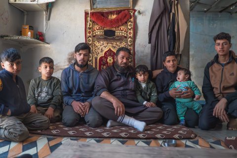 Foto på en grupp människor som sitter ner på en matta.