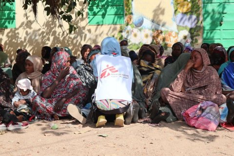 Kvinnor sitter i skuggan av ett träd