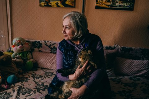 En kvinna med en katt i famnen.