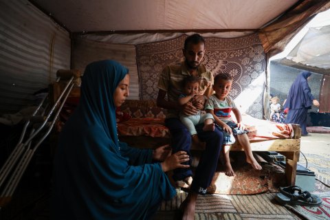 En kvinna, en man och två barn i ett tält.