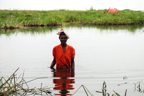 Kvinna vadar med barn som ska vaccineras mot mässling