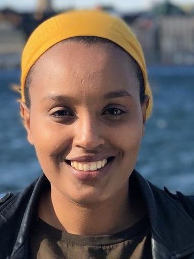 Närdbild på en medelålderskvinna som ler glatt in i kameran.