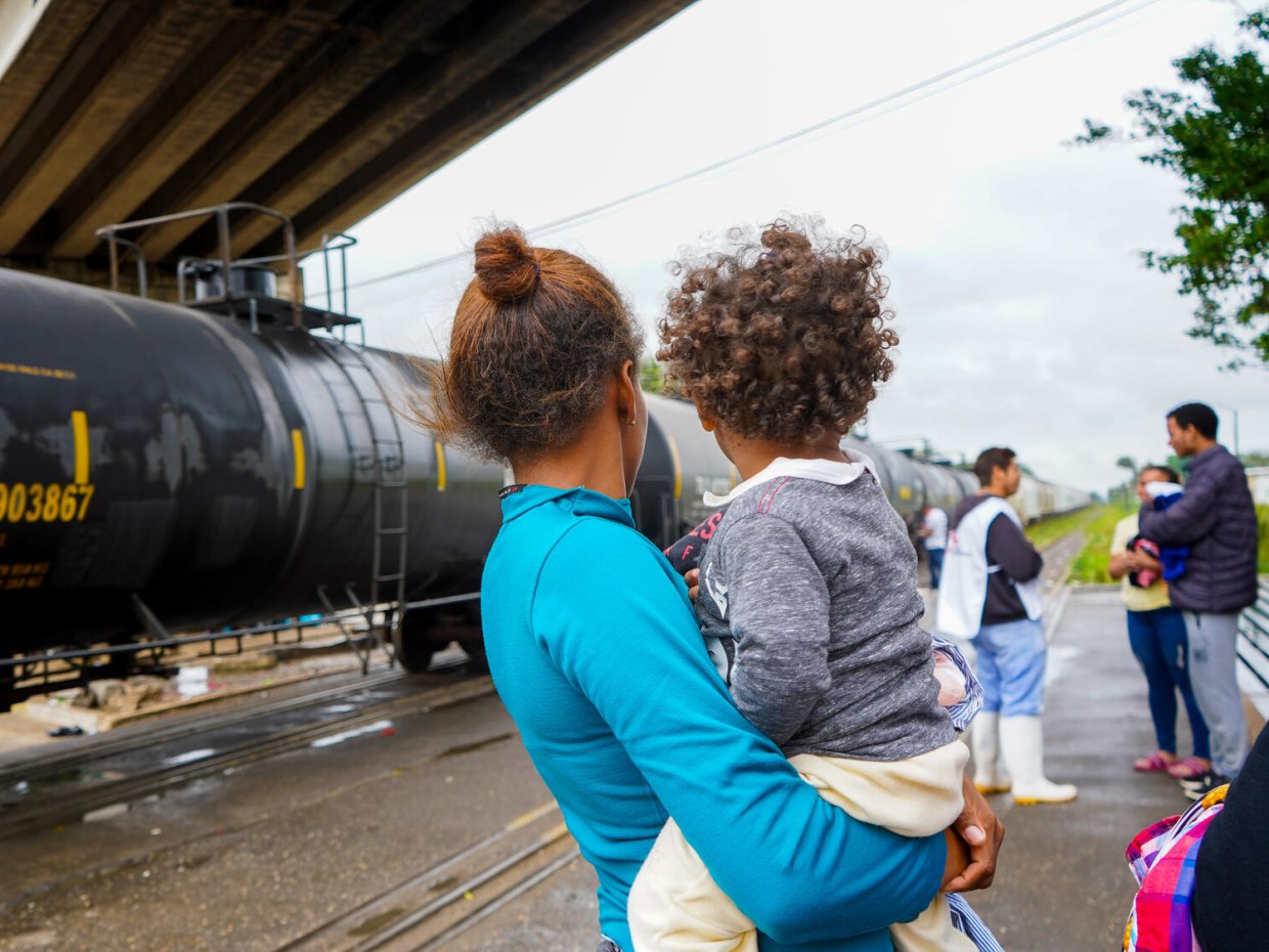 En kvinna håller sitt barn i famnen.