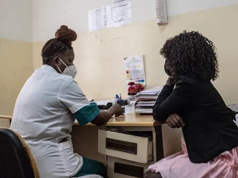 Patient sitter ner mittemot sjuksköterska på en klinik. 