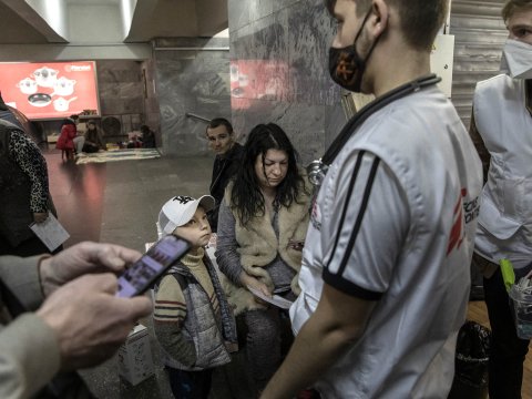 Kvinna och barn tas om hans av vårdpersonal på en tunnelbanestation