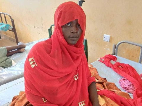 Kvinna sittandes på sjukhussäng